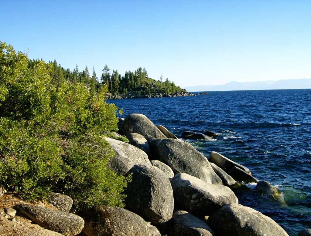 Granite boulders and pines along the Lake Tahoe shoreline under a clear sky